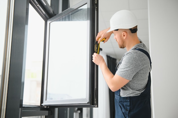 Photo construction worker installing window in house