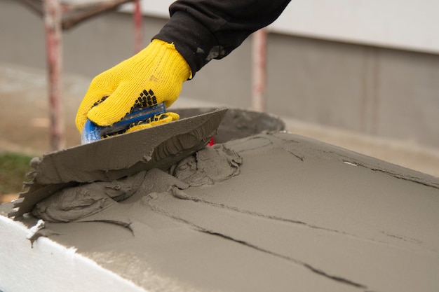 Photo construction worker insulating house wall with styrofoam insulatuion sheet