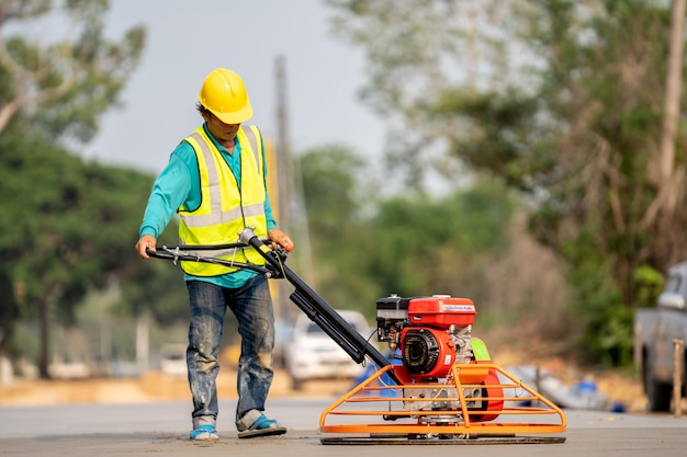 Photo a construction worker pouring a wet concret at road construction site