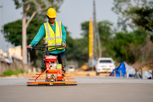 A construction worker pouring a wet concret at road construction site