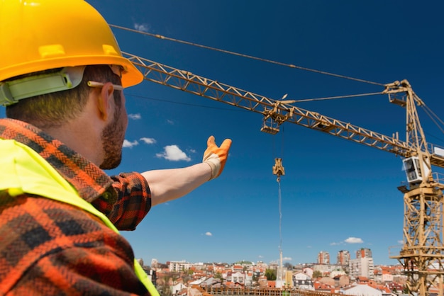 Construction worker signaling to crane operator