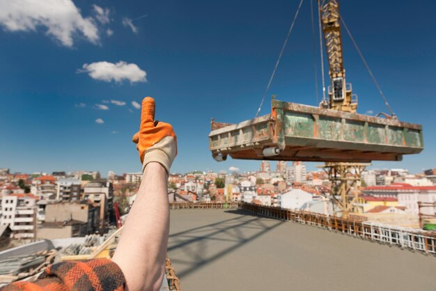 Photo construction worker signaling to crane operator