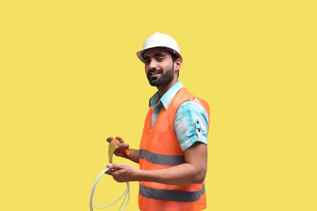 construction worker smiling and holding handsaw with wire indian pakistani model