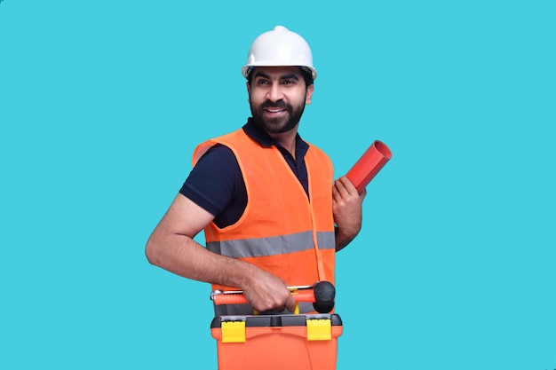 construction worker smiling holding tool box and paper project indian pakistani model
