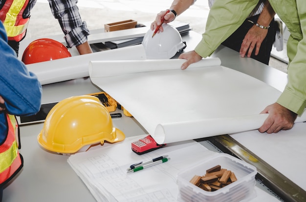 Construction worker team planning about building plan with blueprint, safety helmet