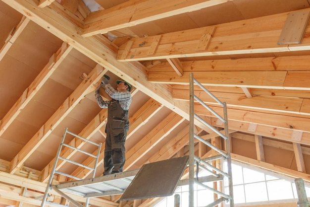 Construction worker thermally insulating eco wooden frame house