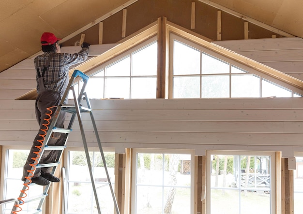 Construction worker thermally insulating eco wooden frame house