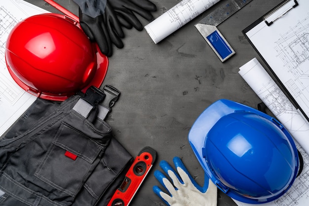 建設労働者unifrom、ヘルメット、木製の背景の青写真