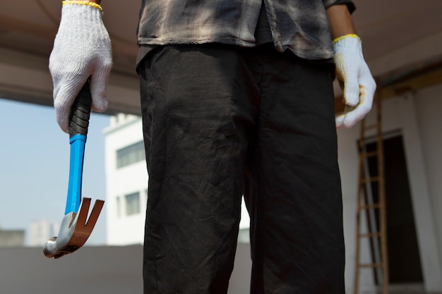 Photo construction worker using hammer at job site