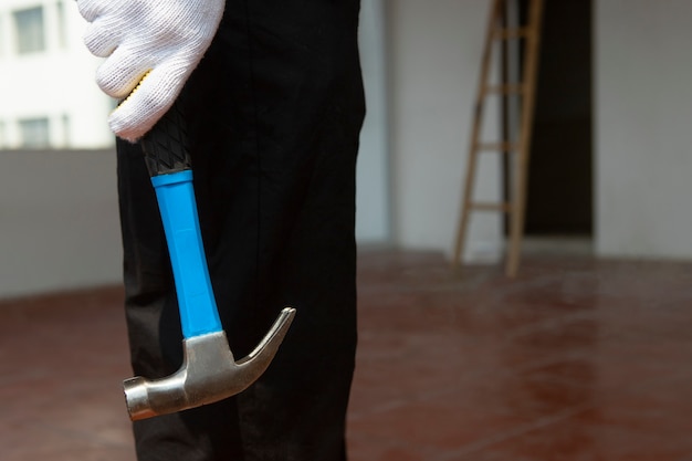 Photo construction worker using hammer at job site