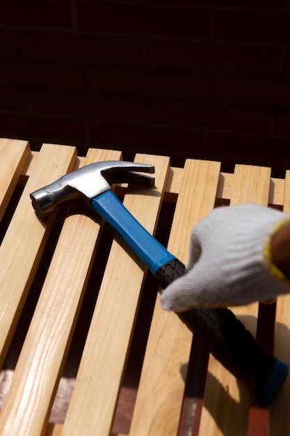 Photo construction worker using hammer at job site