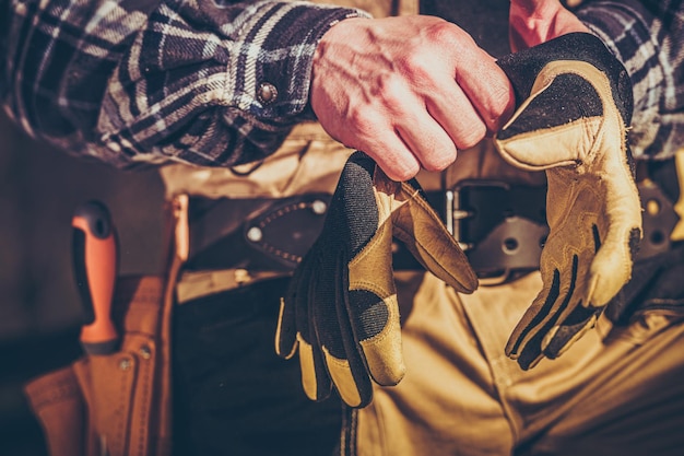 Photo construction worker wearing hands safety gloves