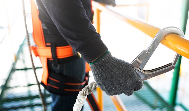 Construction worker wearing safety harness and safety line working on construction