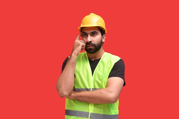 construction worker wearing safety vest and posing over orange background indian pakistani model