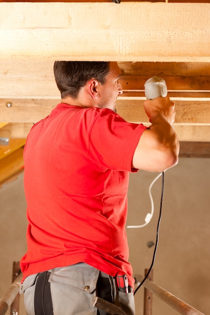 Construction worker with hand drill