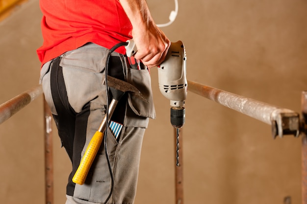 Construction worker with hand drill