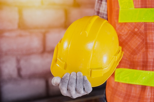 Foto operaio edile, lavoratore con strumento su sfondo di costruzione.