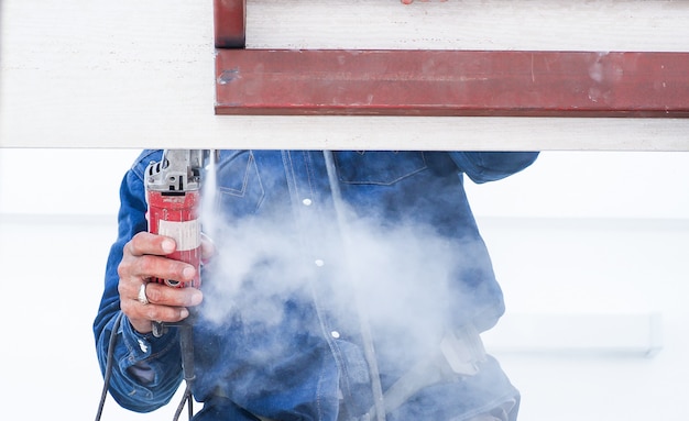 Construction worker working on steel roof structure have measuring and cutting materials.