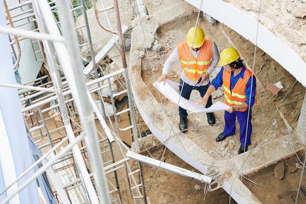 Construction workers discussing blueprint