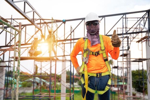 A i lavoratori edili esprimono fiducia dopo aver installato dispositivi di sicurezza per prevenire cadute dall'alto o dispositivo anticaduta per lavoratore con ganci per imbracatura di sicurezza in cantiere