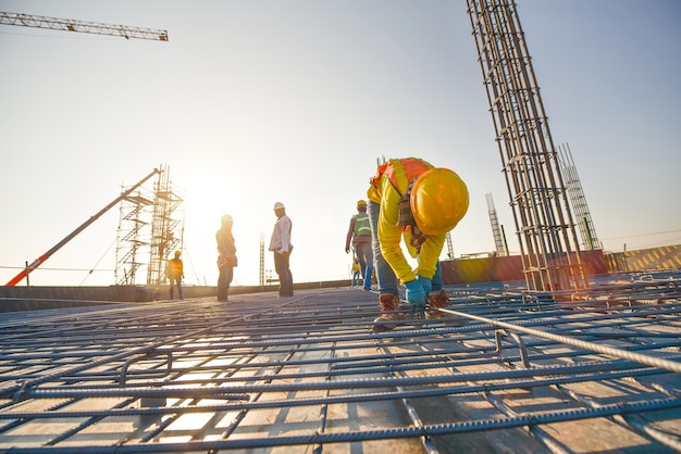 Photo construction workers fabricating steel reinforcement bar at the construction site