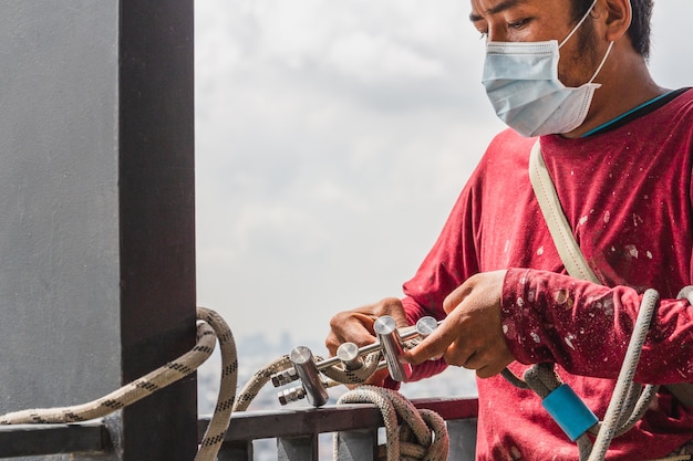 Construction workers holding steel hooks connecting with rope