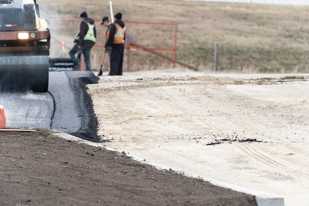 Construction workers laying new tarmac for new parking lot