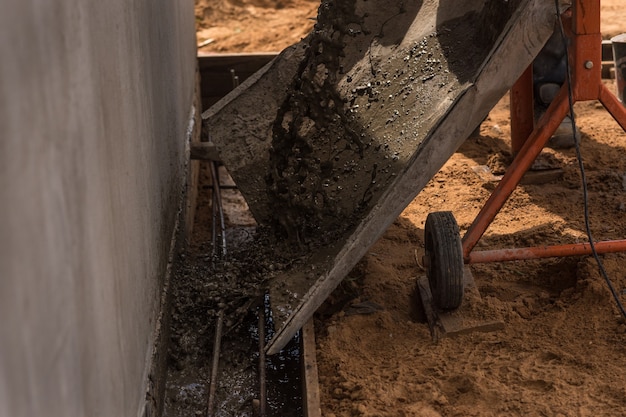 Construction workers pour concrete with a concrete mixer.