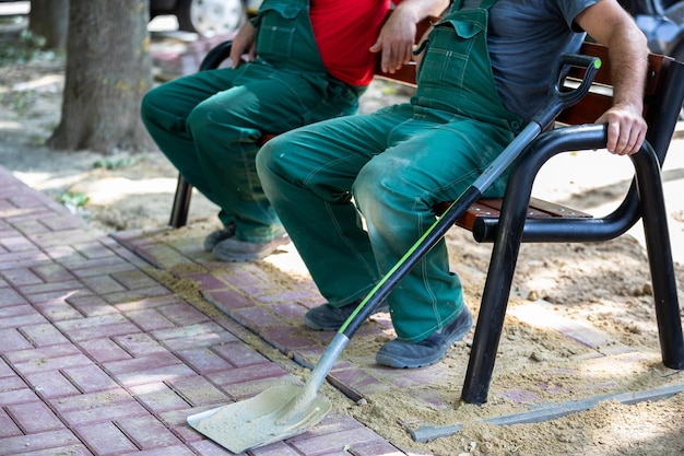 Construction workers rest on a bench after doing hard work