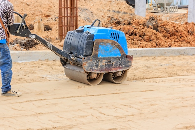 Construction workers during road roller at work on the road construction