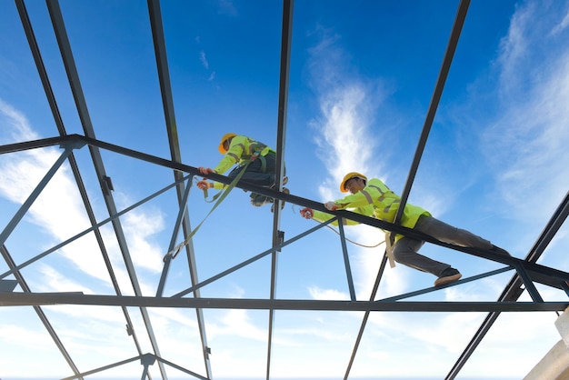 Construction workers wear safety harnesses and safety harnesses working on industrial metal roofs