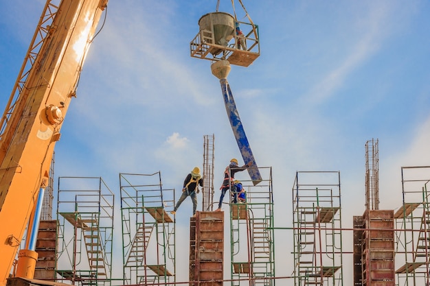 Construction workers working on scaffolding at a high level include a safety belt 