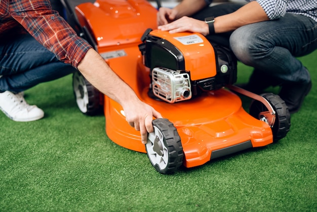 Consultant shows a guy and a girl a lawn mower.