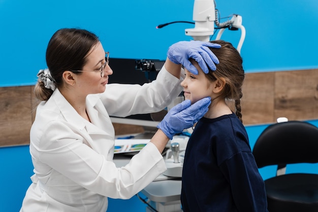 Consultation for children at ophthalmological clinic for treatment of eye inflammation and vision correction Pediatric ophthalmologist examines eyes and pupil of child