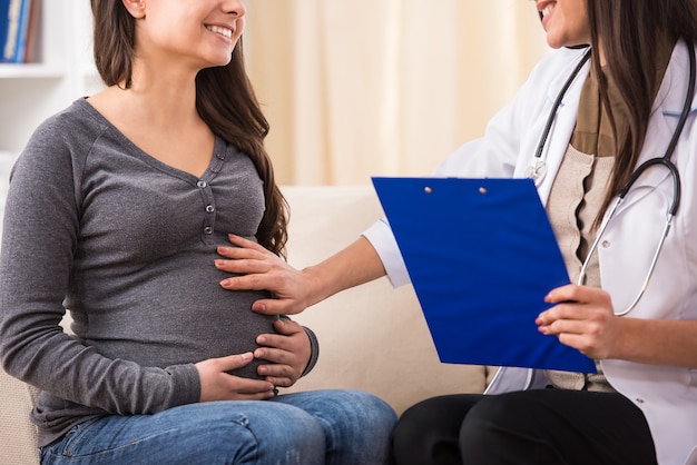 Consultation of pregnant young woman with doctor.