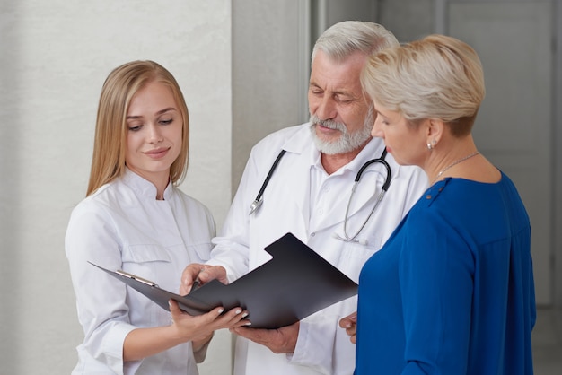 Consultation of two doctors and woman in hospital.