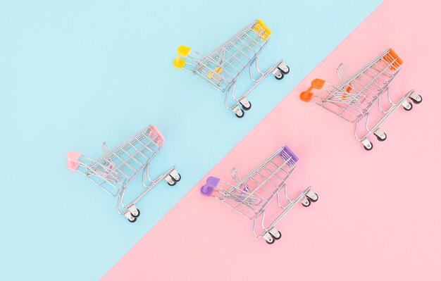 Consumentenconcept mini-winkelwagentje om te winkelen op een gekleurde achtergrond minimalisme bovenaanzicht