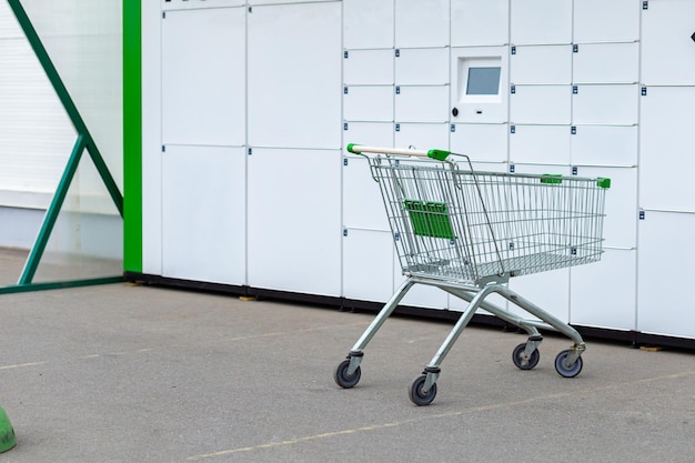 Consumentenmand op wielen om te winkelen tegen de achtergrond van brievenbussen