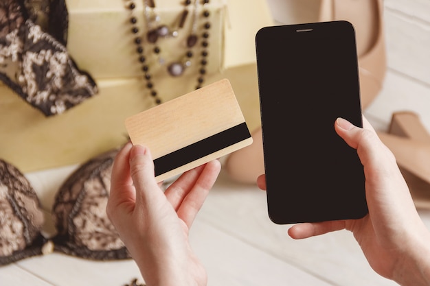 Consumentisme en verkoopconcept - sluit omhoog van vrouwelijke hand met creditcard en smartphone