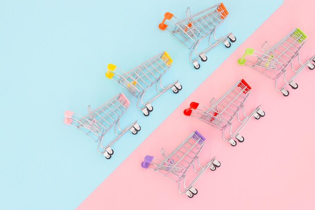 Consumer concept mini shopping trolley for shopping on a colored background minimalism top view