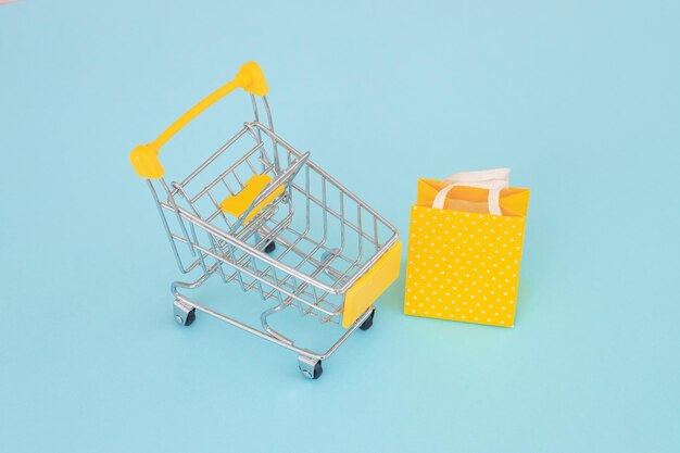 컬러 배경 평면도에서 쇼핑하기 위한 소비자 개념 미니멀리즘 미니 쇼핑 트롤리