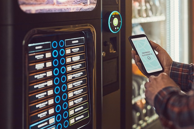 consumer paying for product at vending machine using contactless method of payment with mobile phone