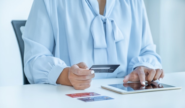 Foto mano della donna del consumatore che tiene una carta di credito simulata pronta a spendere lo shopping finanziario online di pagamento