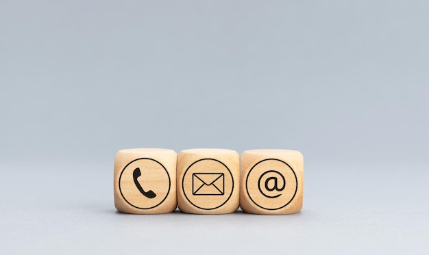 Contact icons on wooden blocks on gray background Copy space