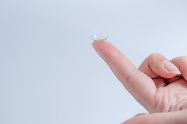 Крупный план контактных линз на кончике пальца женщины