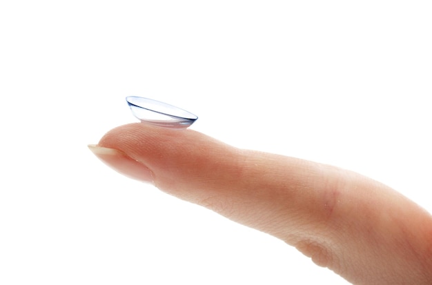 Contact lens on finger isolated on white