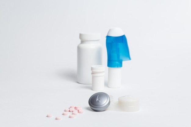 Contact lenses container and pile of pills placed against bottles