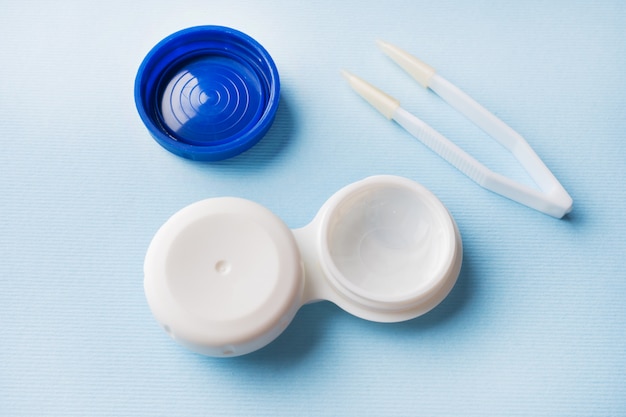 Contact lenses, tweezers and lens storage container. Close up. Selective focus.