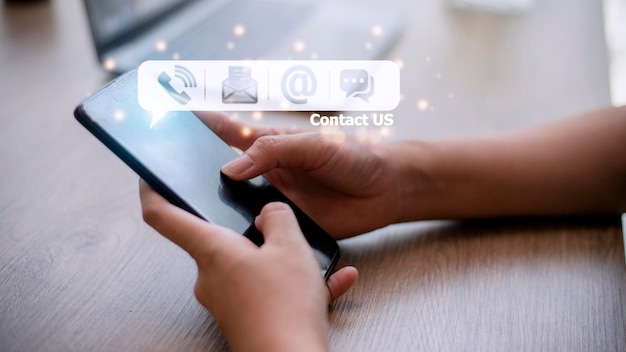 Contact us hand of people holding mobile smartphone with mail\
phone email chat icon customer support concept