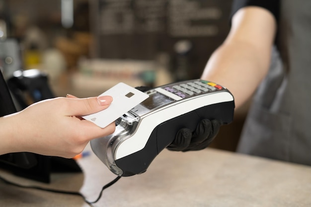 Contactless debit card payment customer hand paying contactless credit card with NFC technology Bartender with card reader